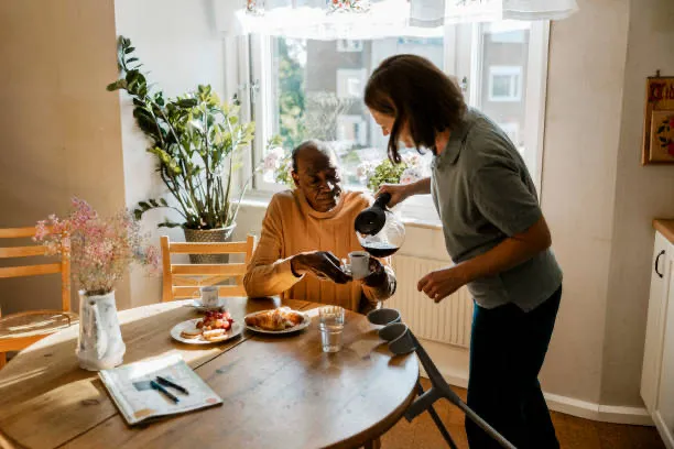 A Twinkling Hearts caregiver serving breakfast to a senior client at home